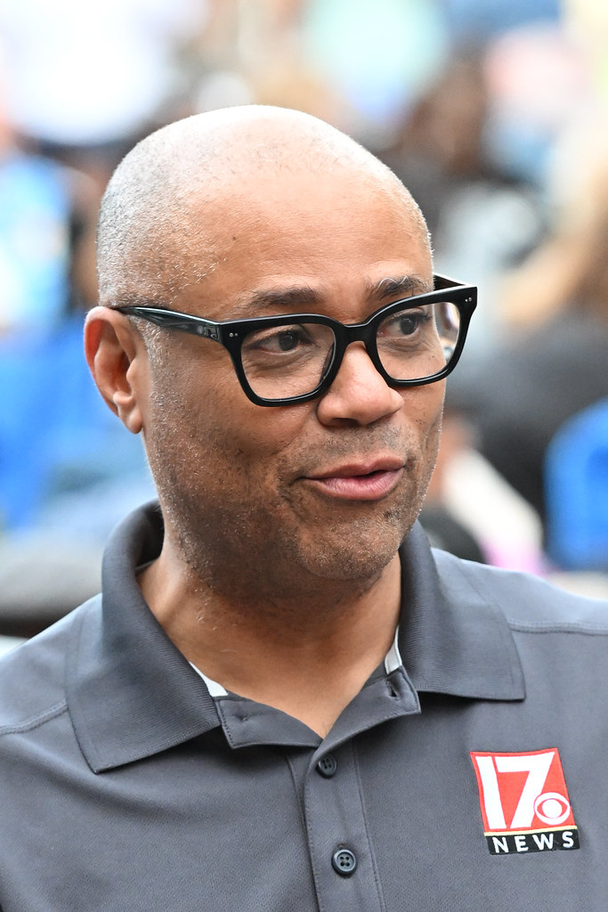 17 News Logolu Haber Muhabiri Portresi, Siyah Gözlük ve Gri Polo Tişört