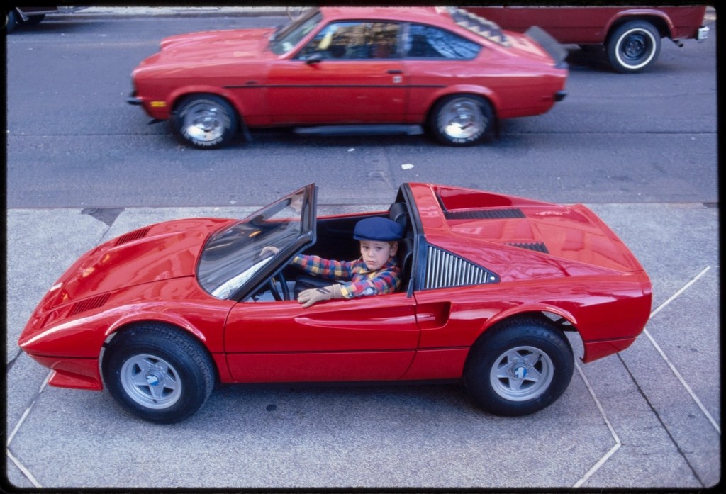 1970lerden nostaljik kare: Kırmızı oyuncak Ferrari'de şapkalı küçük bir çocuk