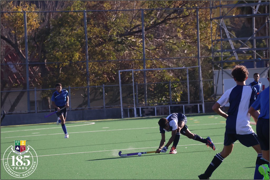 Açık havada hokey antrenmanı yapan genç sporcular ve yeşil saha manzarası