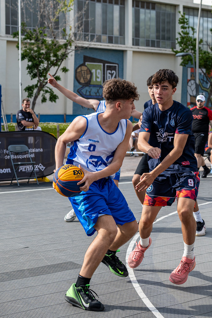 Açık havada sokak basketbolu oynayan gençlerin rekabetçi ve dinamik maç anı