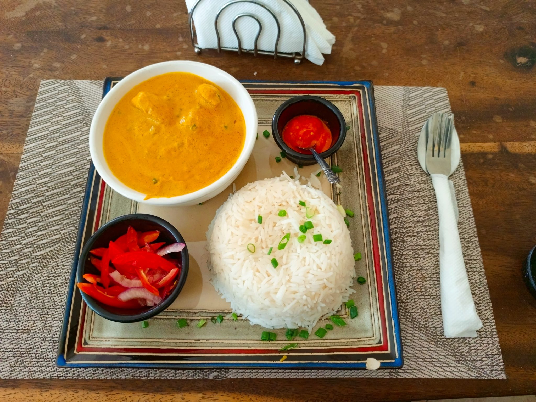 Ahşap Masa Üzerinde Özenle Sunulmuş Tavuk Köri, Basmati Pilav ve Acı Sos