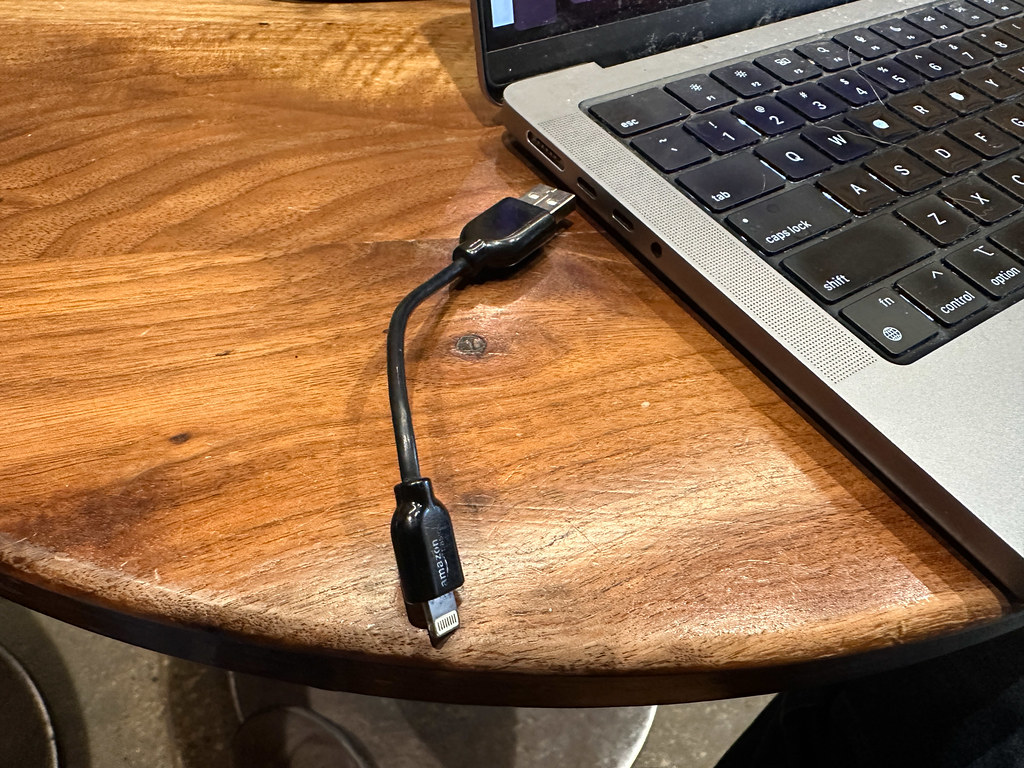ahşap masada dizüstü bilgisayar ve usb c şarj kablosu yakın çekim