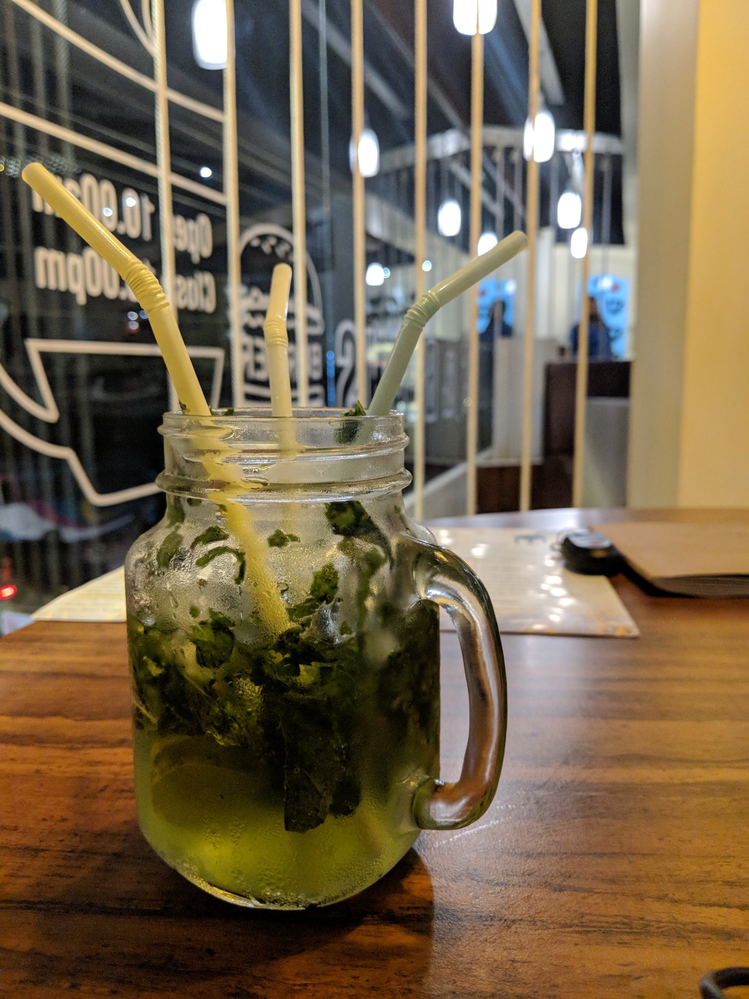 Ahşap Masada Kavanoz Bardakta Ferahlatıcı Naneli Limonata ve Sıcak Kafe Işıkları