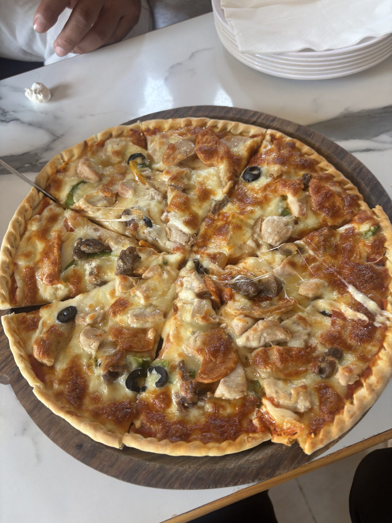 Ahşap Sunum Tahtası Üzerinde Sıcak Tavuklu Mantarlı Pizza ve Restoran Masası