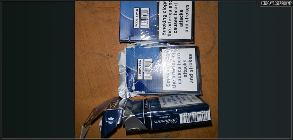 Ahşap zeminde duran sigara paketleri ve dikkat çeken sağlık uyarı etiketleri