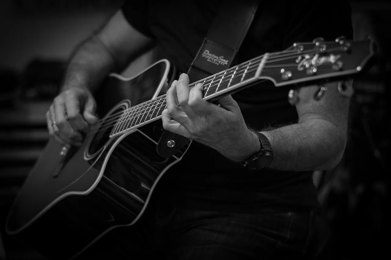 Akustik gitar tutuşu ve çalma anı - müzisyen
