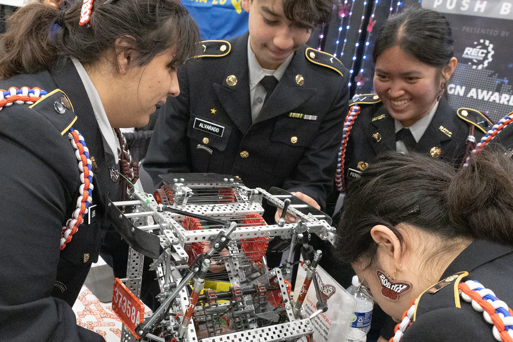 Askeri üniformalı öğrenciler robotik yarışmasında takım çalışması yapıyor