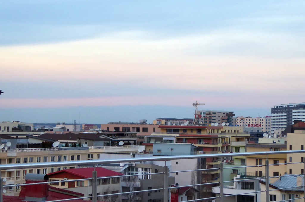 Balkon Korkuluğundan Gün Batımında Şehir Manzarası ve Pastel Renkler