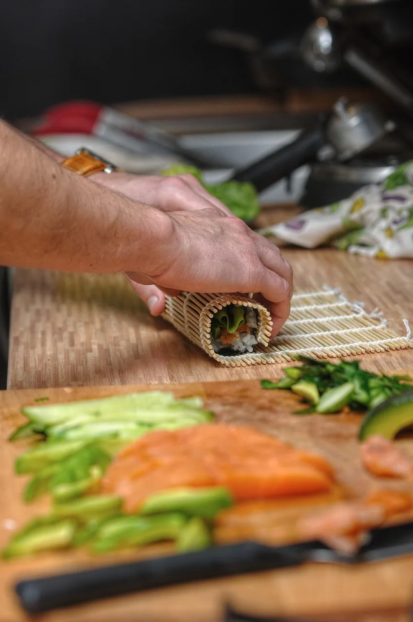 Bambu sarma matı üzerinde sushi hazırlanışı - lezzetli Japon yemeği