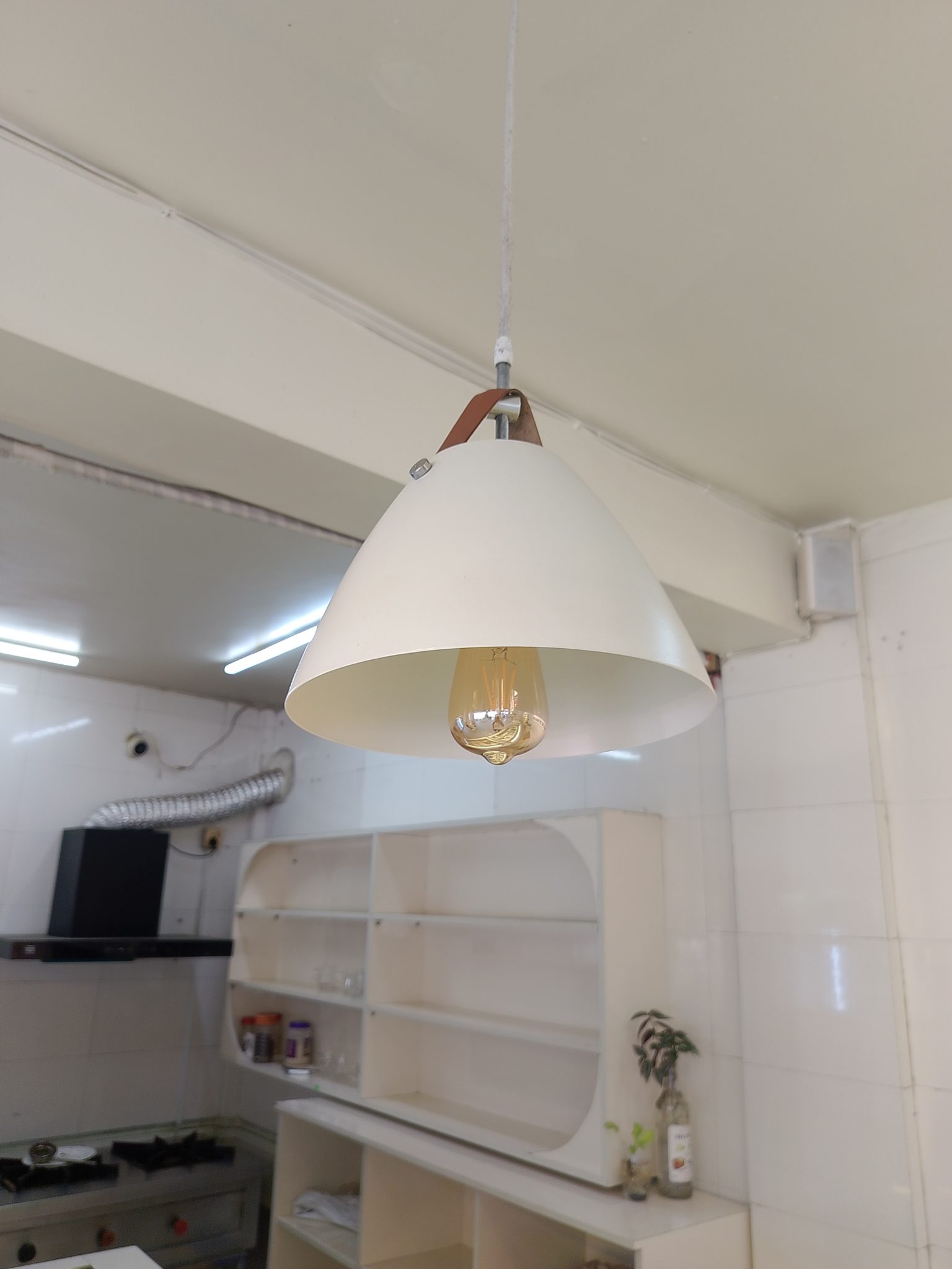 Beyaz Mutfakta Modern Sarkıt Avize ve Minimalist Boş Duvar Rafları
