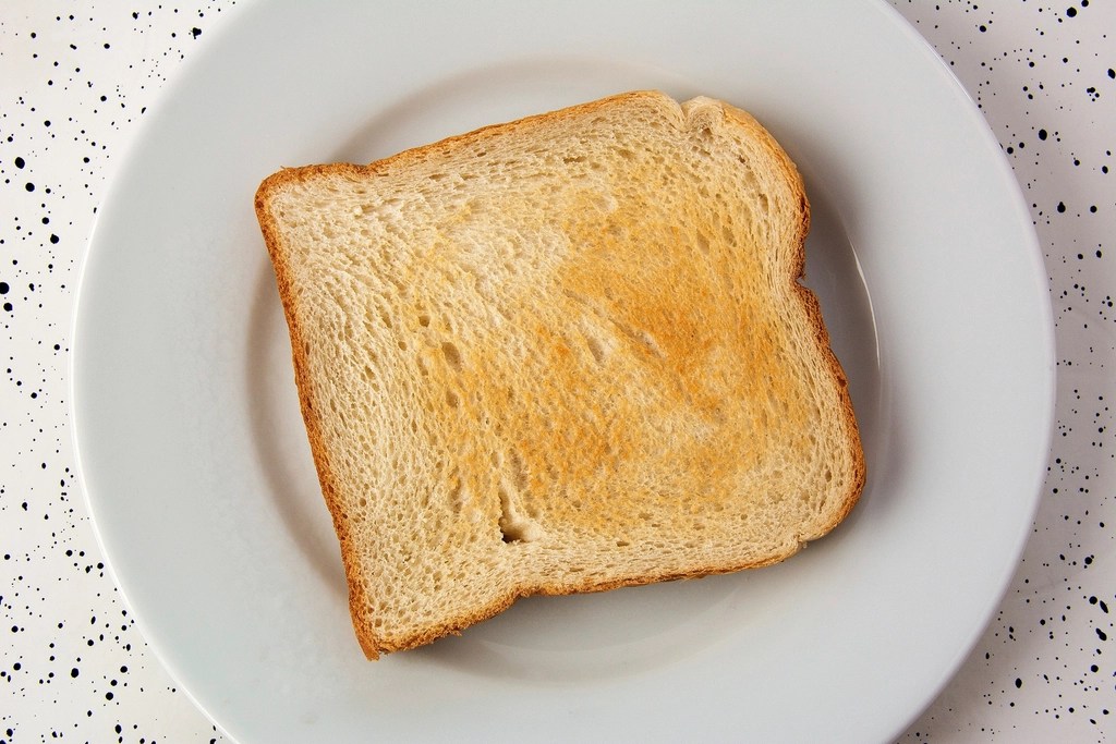Beyaz Tabakta Altın Rengi Kızarmış Tost Ekmeği ve Sade Kahvaltı Sunumu