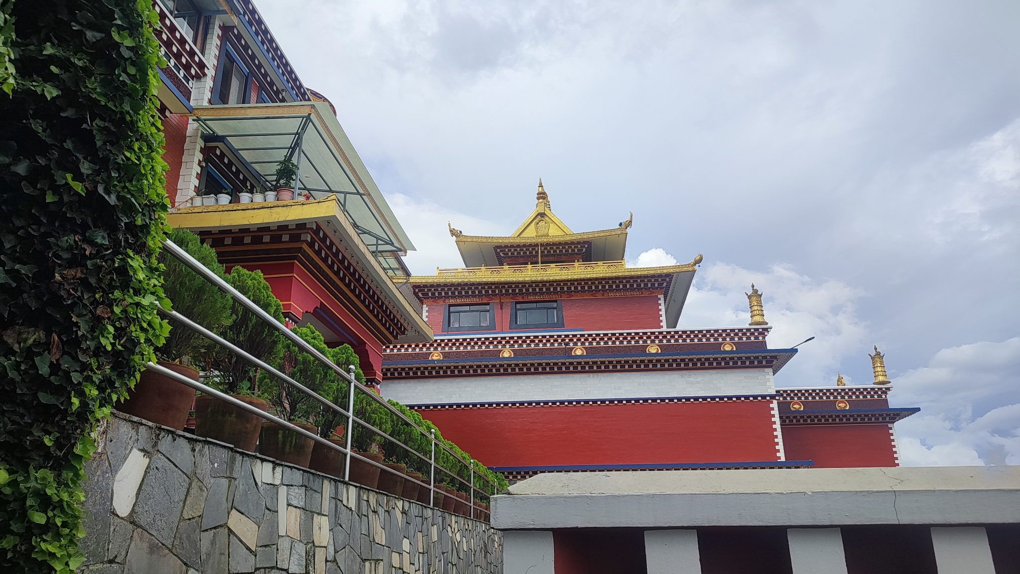 Bulutlu Gökte Altın Çatılı Kırmızı Duvarlı Geleneksel Tibet Tapınağı