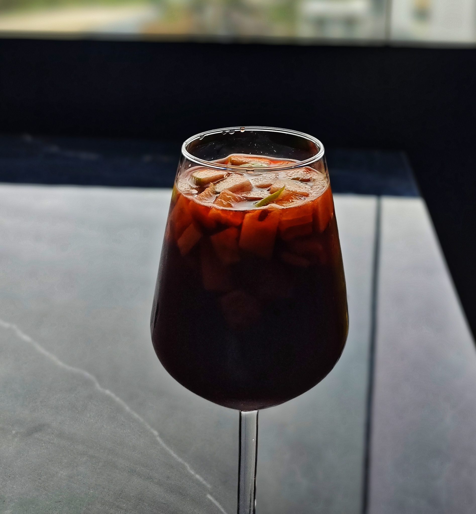 Büyük Şarap Bardağında Meyve Dilimleriyle Süslenmiş Serinletici Kırmızı Sangria