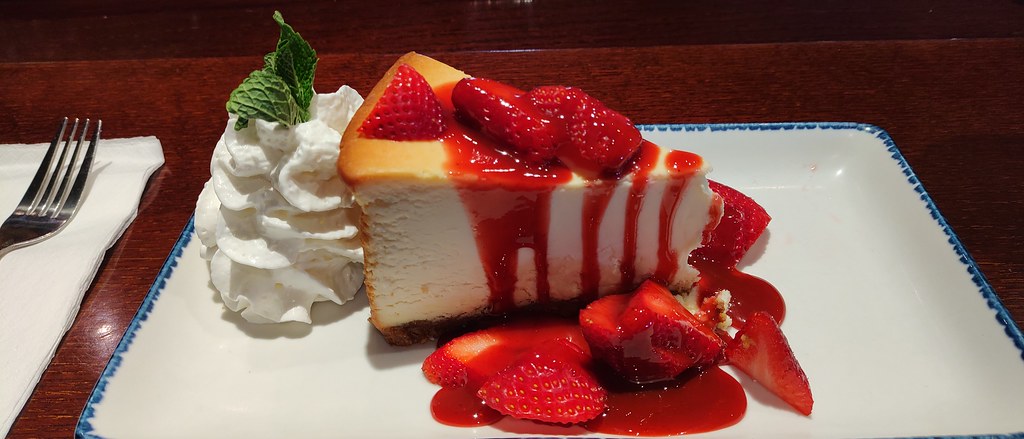 Çilek Soslu Cheesecake Dilimi Çırpılmış Krema ve Nane Süslemesi