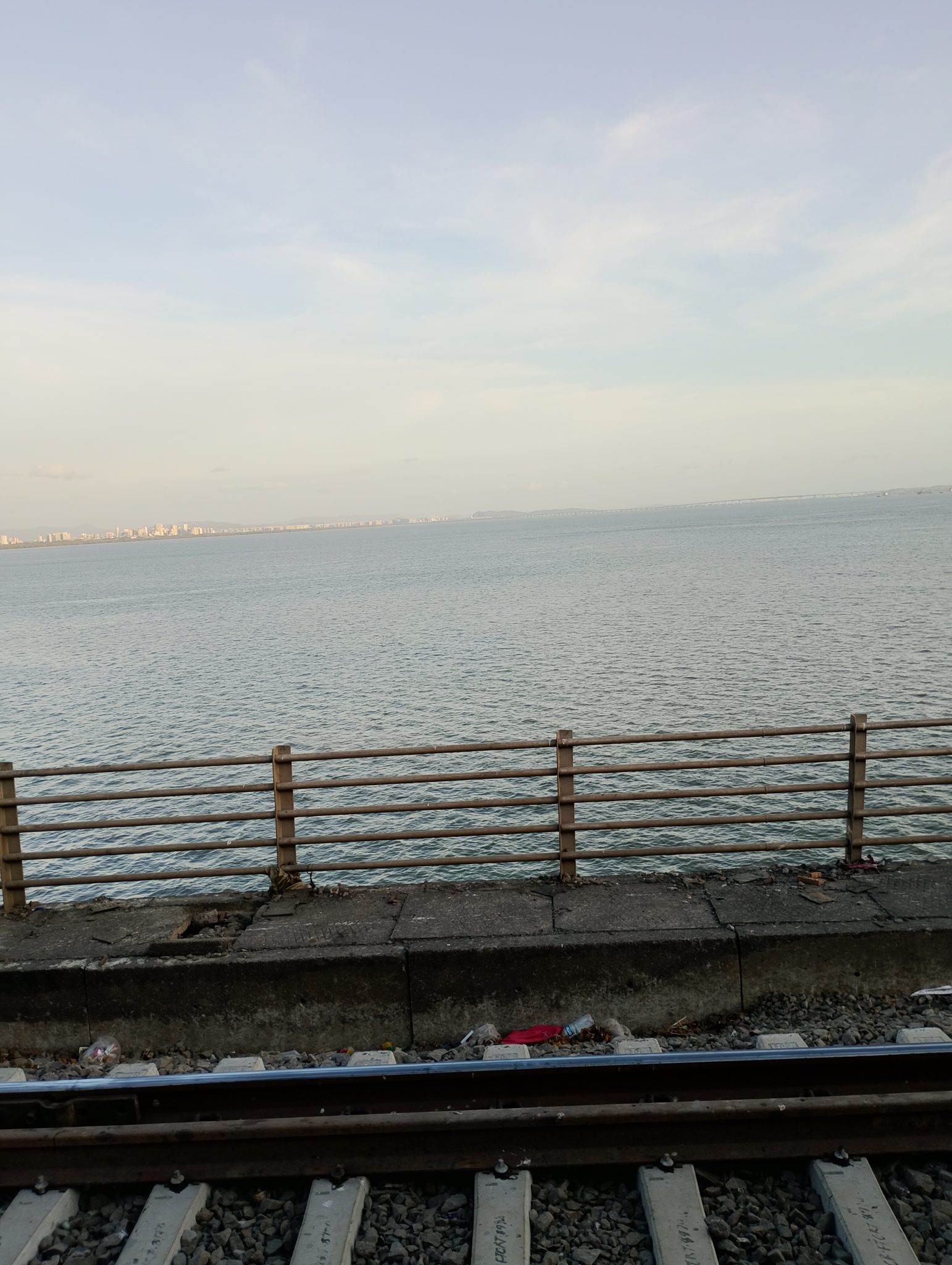 Demir Yolu Kenarında Huzur Verici Deniz Manzarası ve Uzaklardaki Şehir Silueti