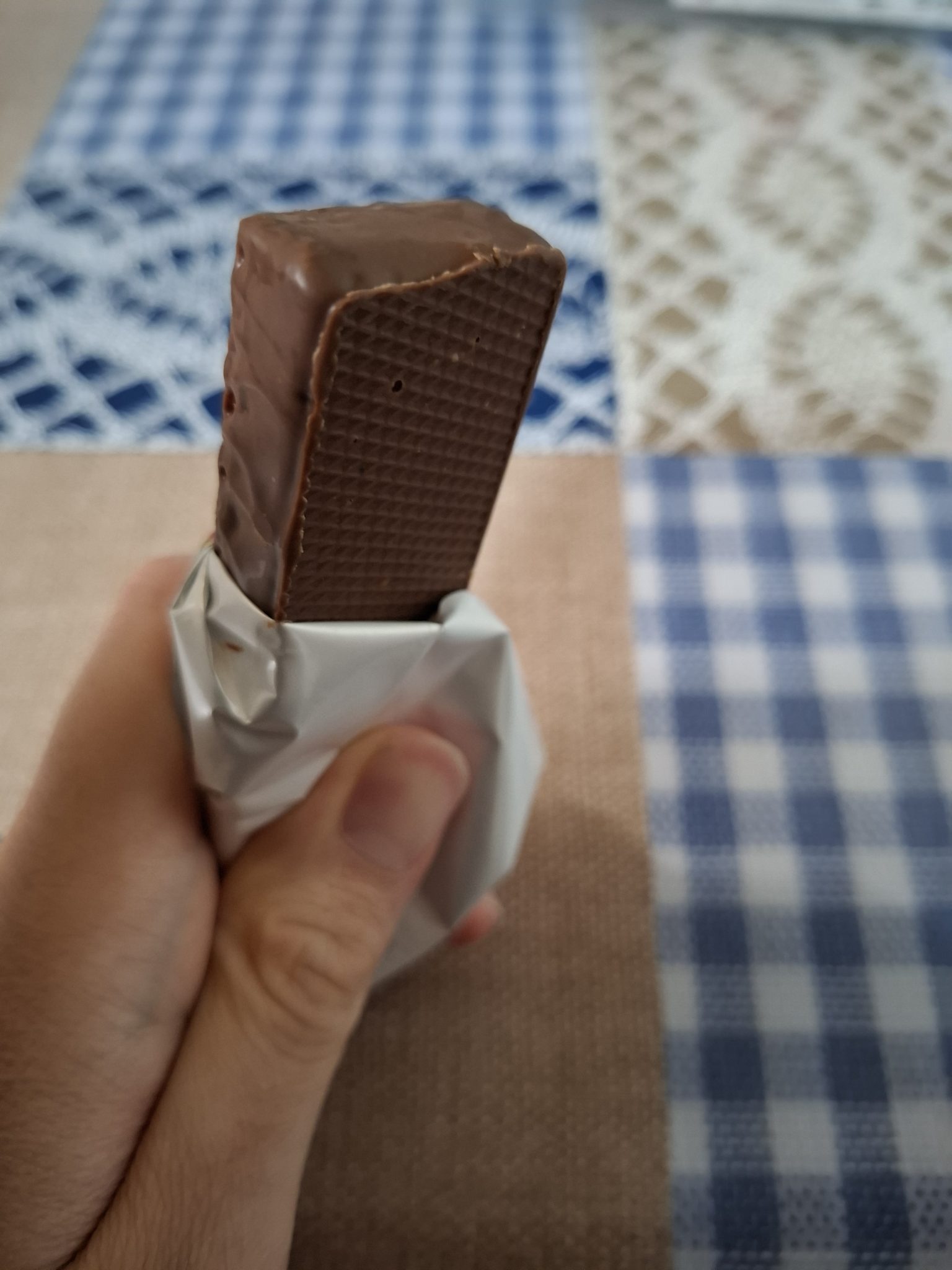 Elimde tuttuğum ısırılmış çikolatalı gofretin yakın plan lezzet dolu anı