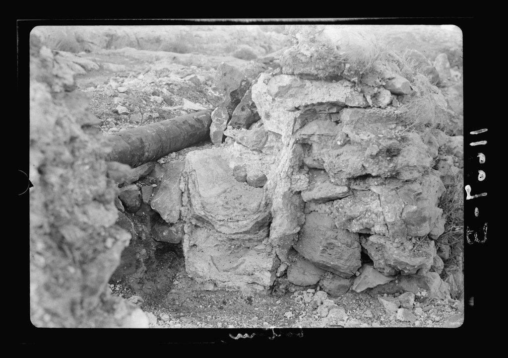 eski siyah beyaz arşiv fotoğrafında kayalık arazide taş duvar ve boru görünümü