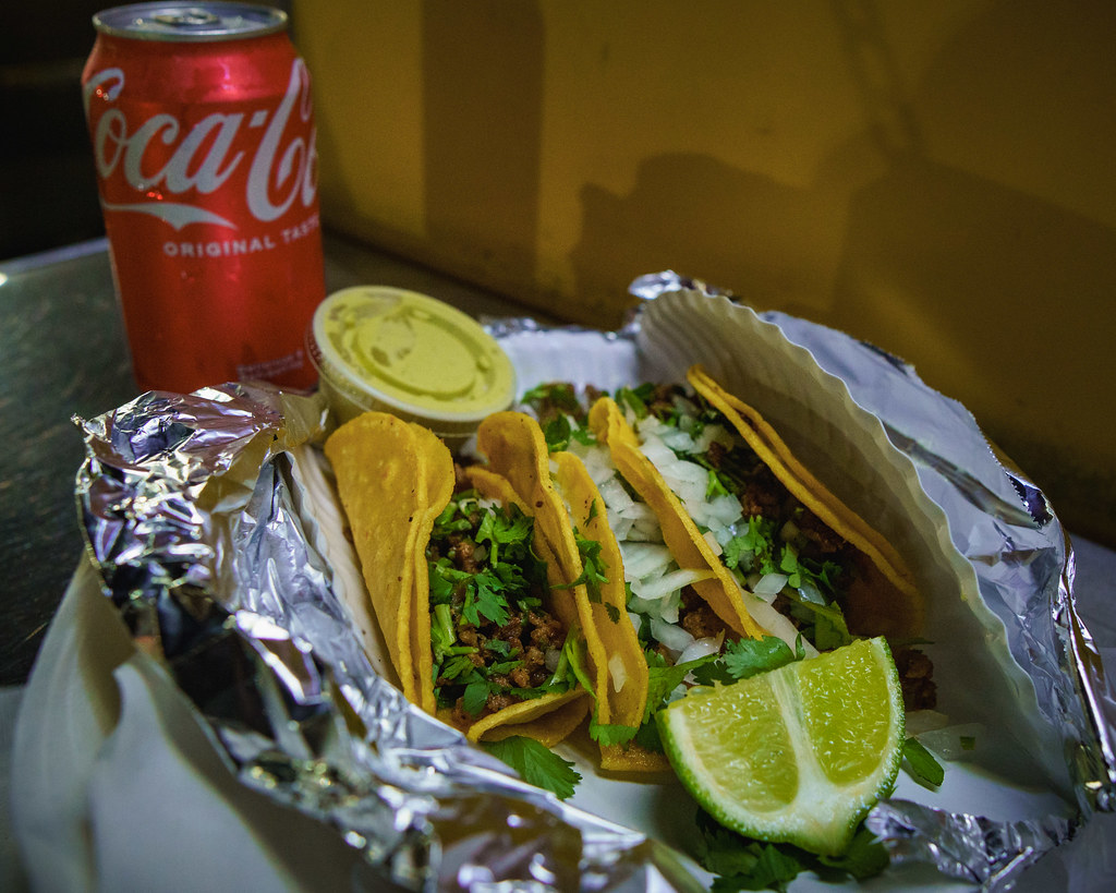 Folyo ambalajda taco, kırmızı Coca-Cola ve limon ile Meksika sokak lezzeti