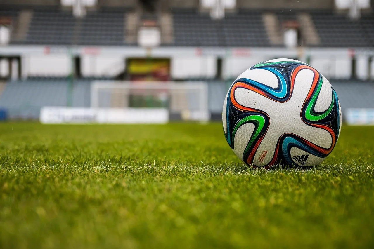 Futbol topu ve çim sahada spor atmosferi