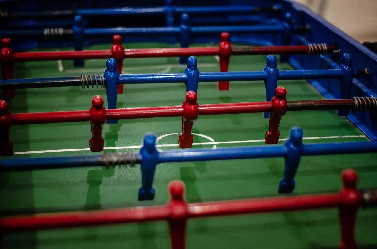 Futbol topu ve oyuncularla dolu stadyum sahası