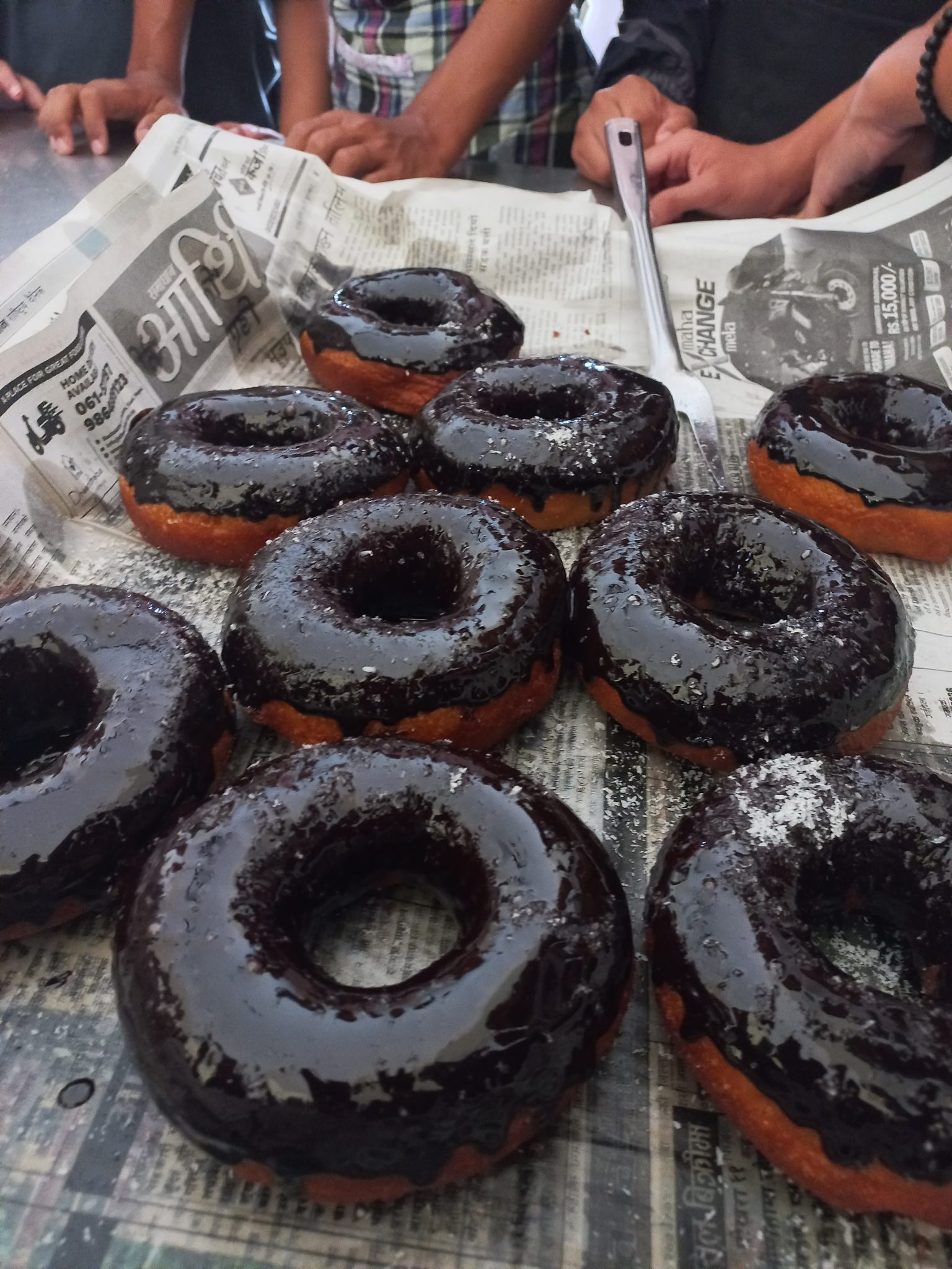 Gazete Kağıdı Üzerinde Parlak Çikolatalı Donutlar ve Arkadaş Sohbeti