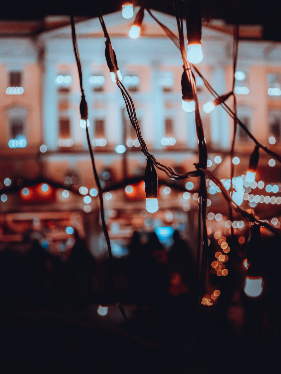 Gece Meydanında Tarihi Bina Önünde Sıcak Ampul Işıkları ve Bokeh Atmosferi