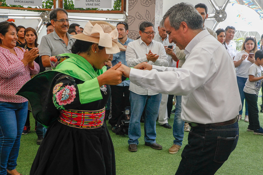 Geleneksel işlemeli elbiseli kadın ve erkeğin festivalde dans ettiği an