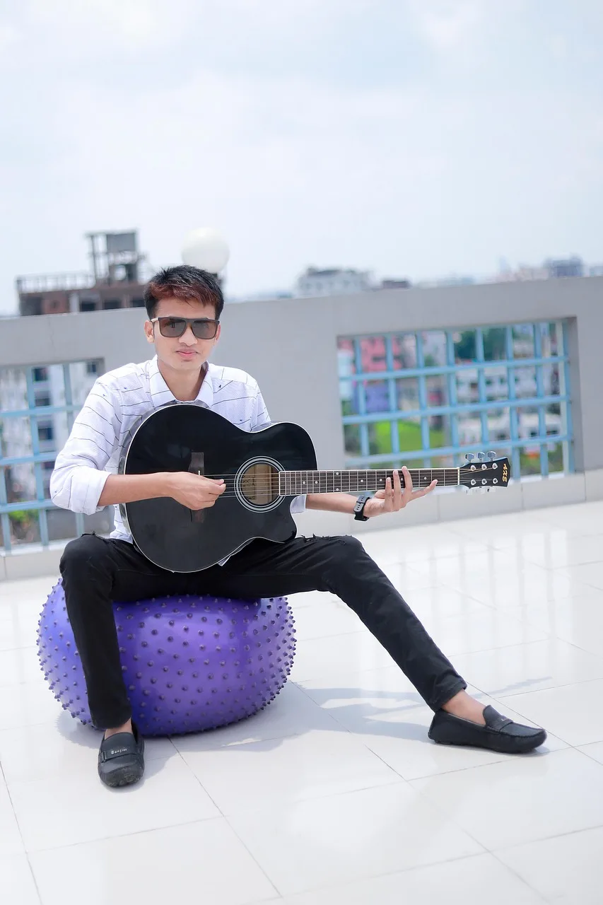 Gitar çalan genç erkek çatı katı fotoğrafı