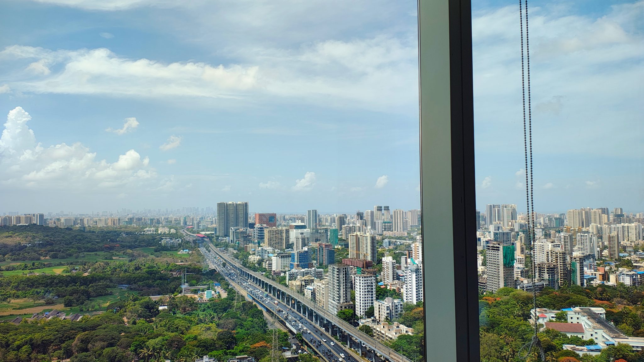 Gökdelen Penceresinden Modern Şehir Panoraması ve Bulutlu Mavi Gökyüzü