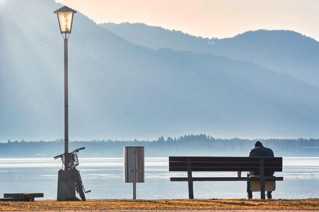 Göl kenarında yalnız bisikletli kişi