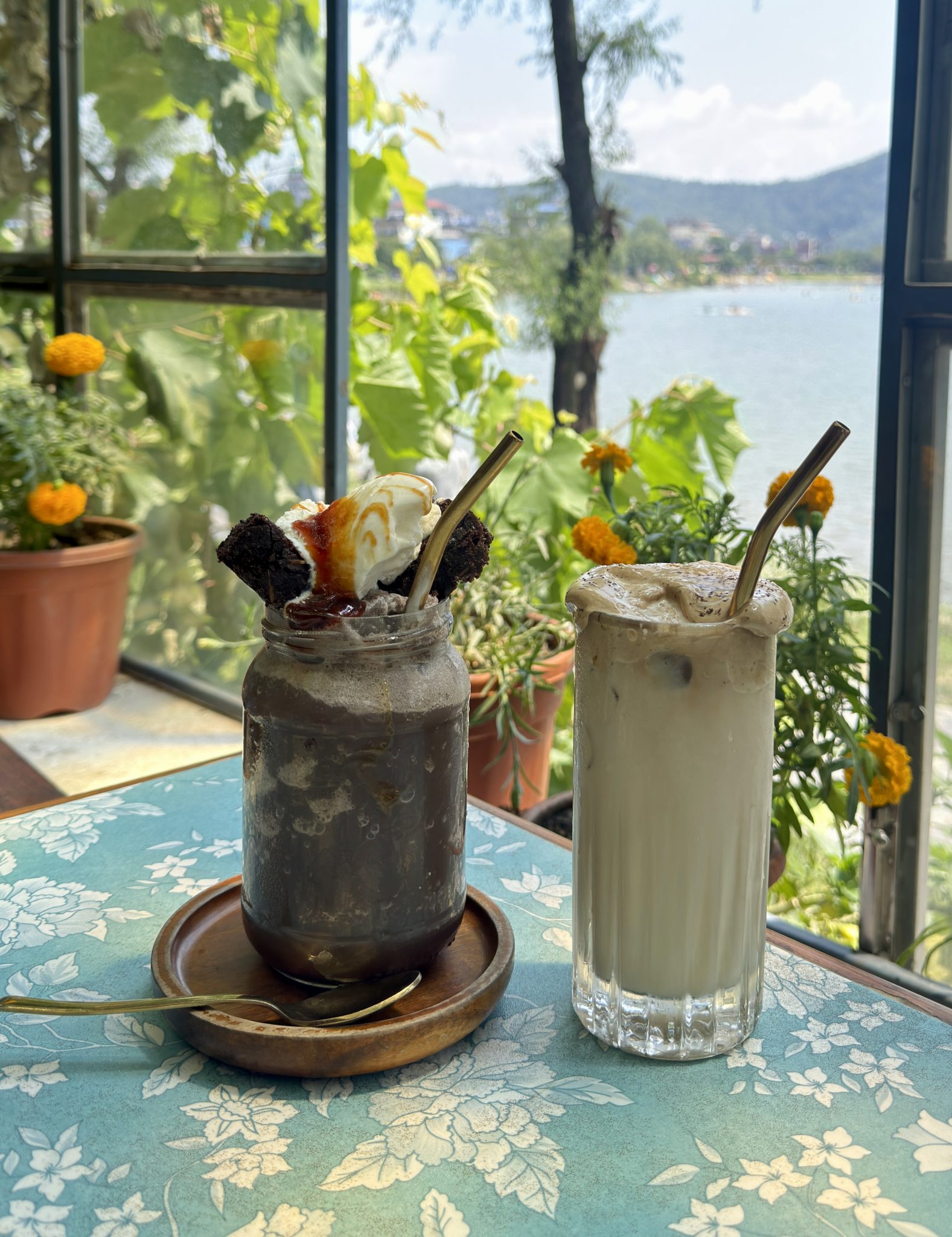 Göl Manzaralı Kafe Köşesinde Sunulan Soğuk Kahve ve Sütlü Tatlı İçecek