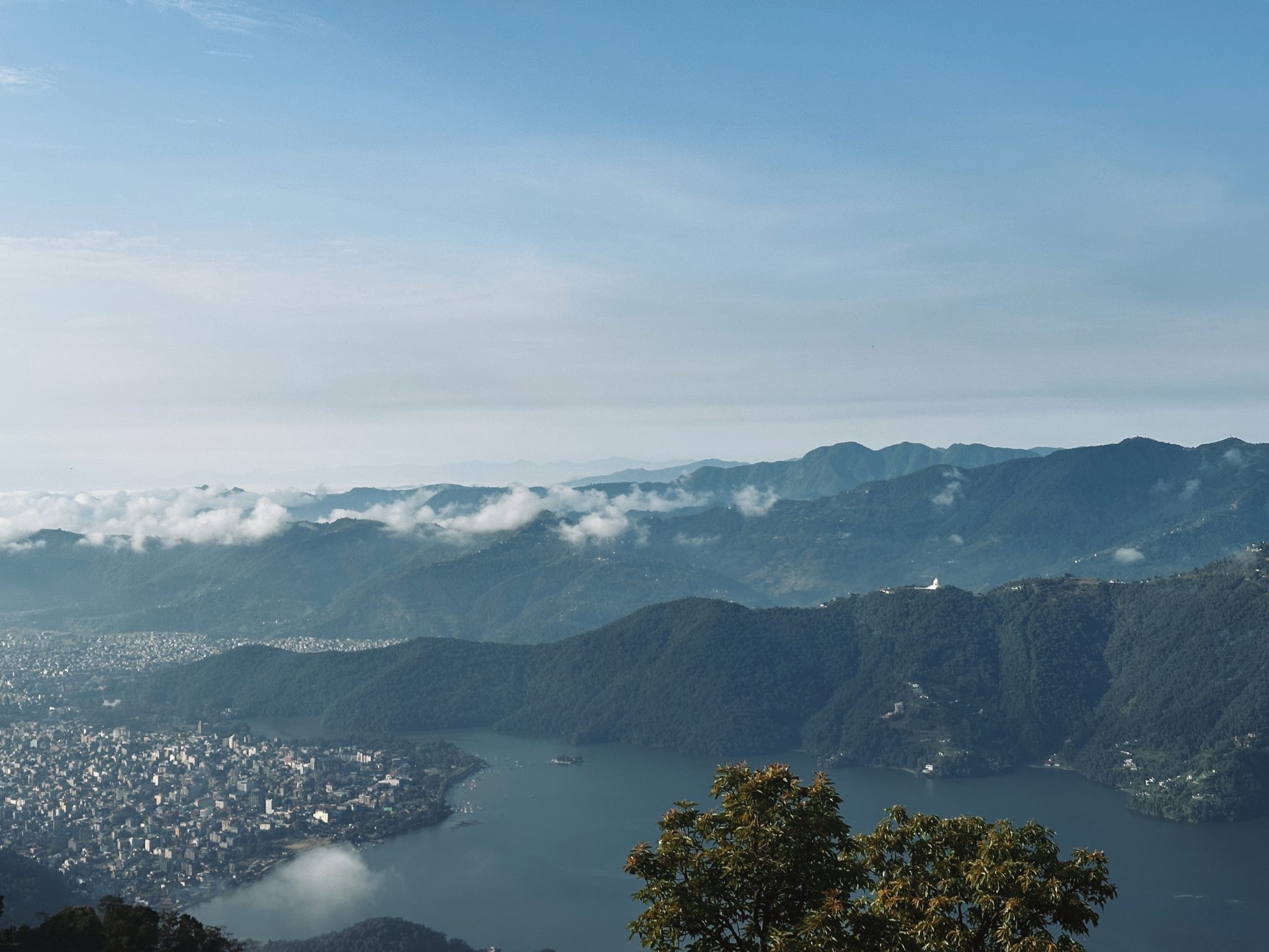 Göl ve Şehrin Buluştuğu Sisli Dağların Huzurlu Panoramik Manzarası