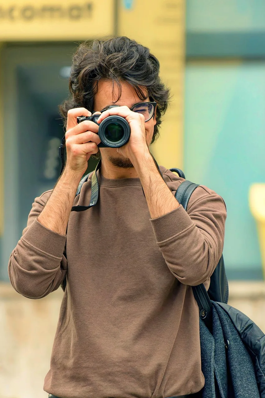 Gözlüklü genç fotoğrafçı çocuk dışarıda kamerayla