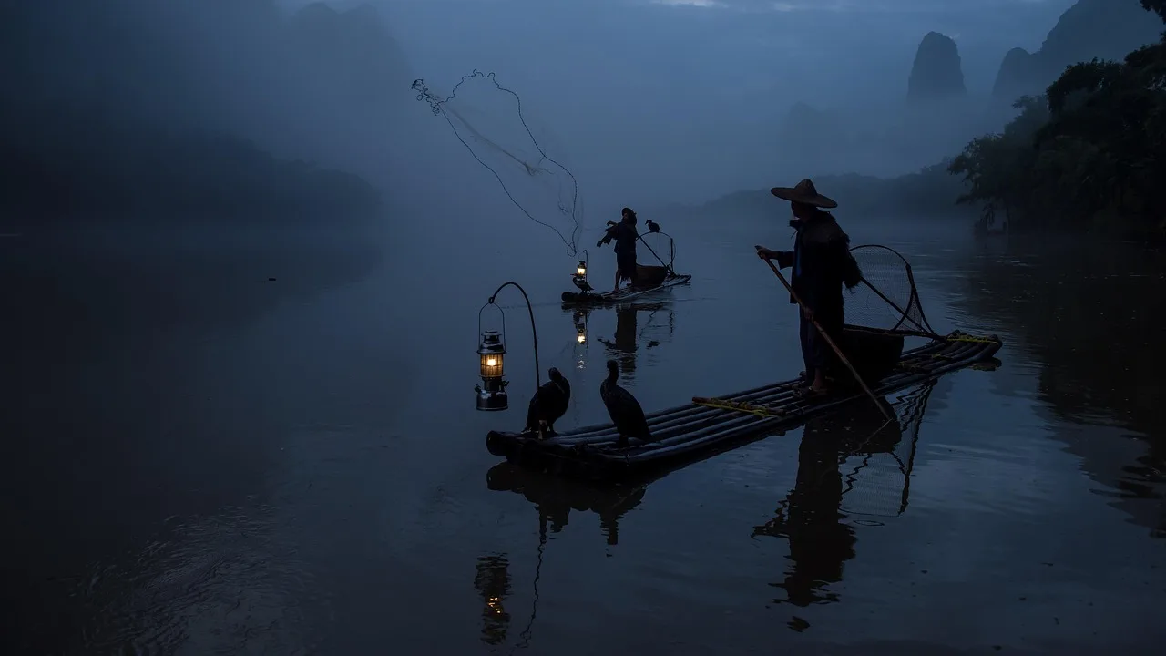 Guilin gölünde balıkçılar, tekneler ve balıkçıllar