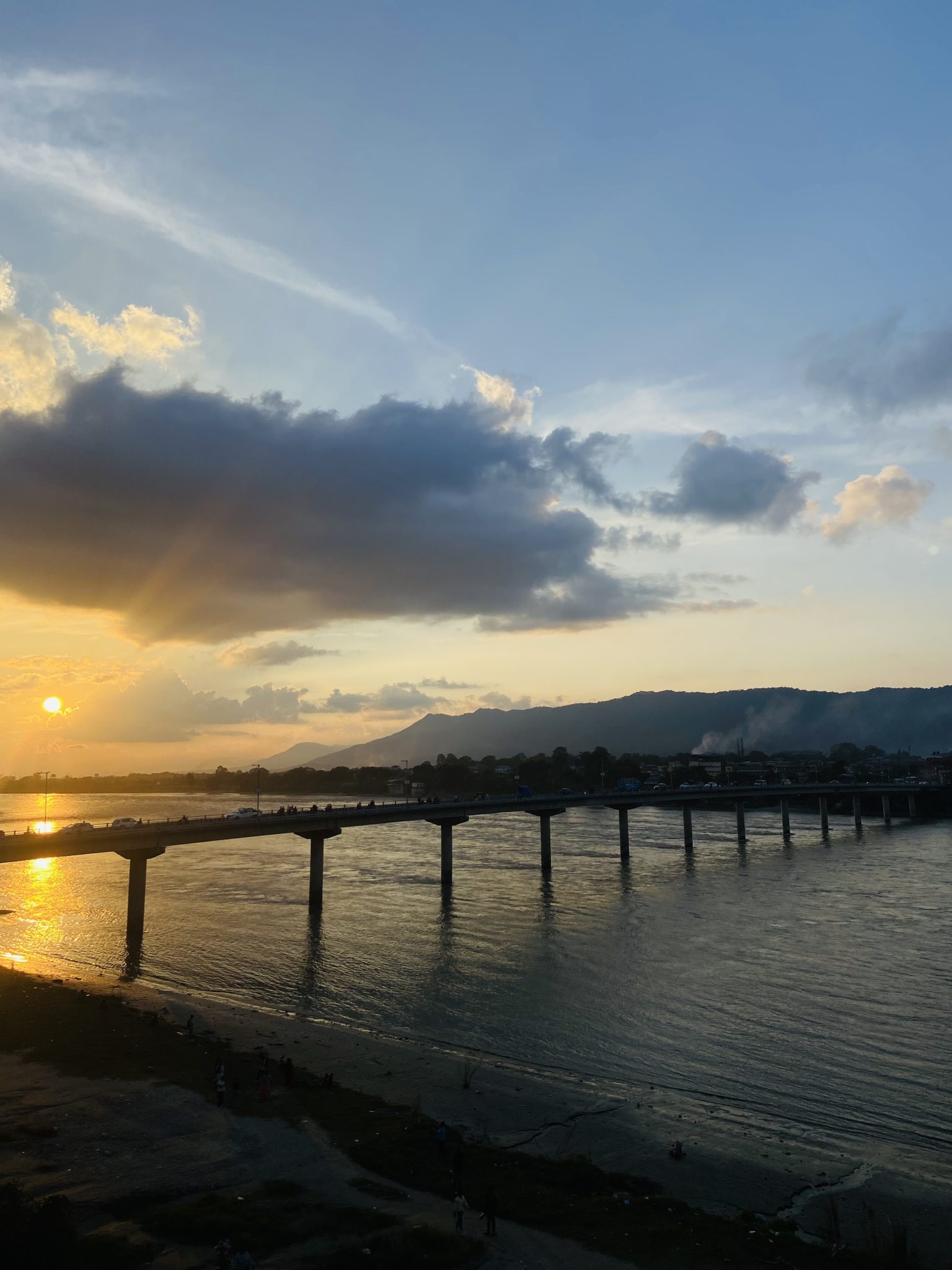 Gün Batımında Altın Tonlarında Parlayan Nehir ve Uzun Köprü Manzarası