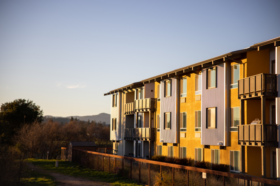 Gün batımında bahçeli modern apartman binası ve dağ manzarası