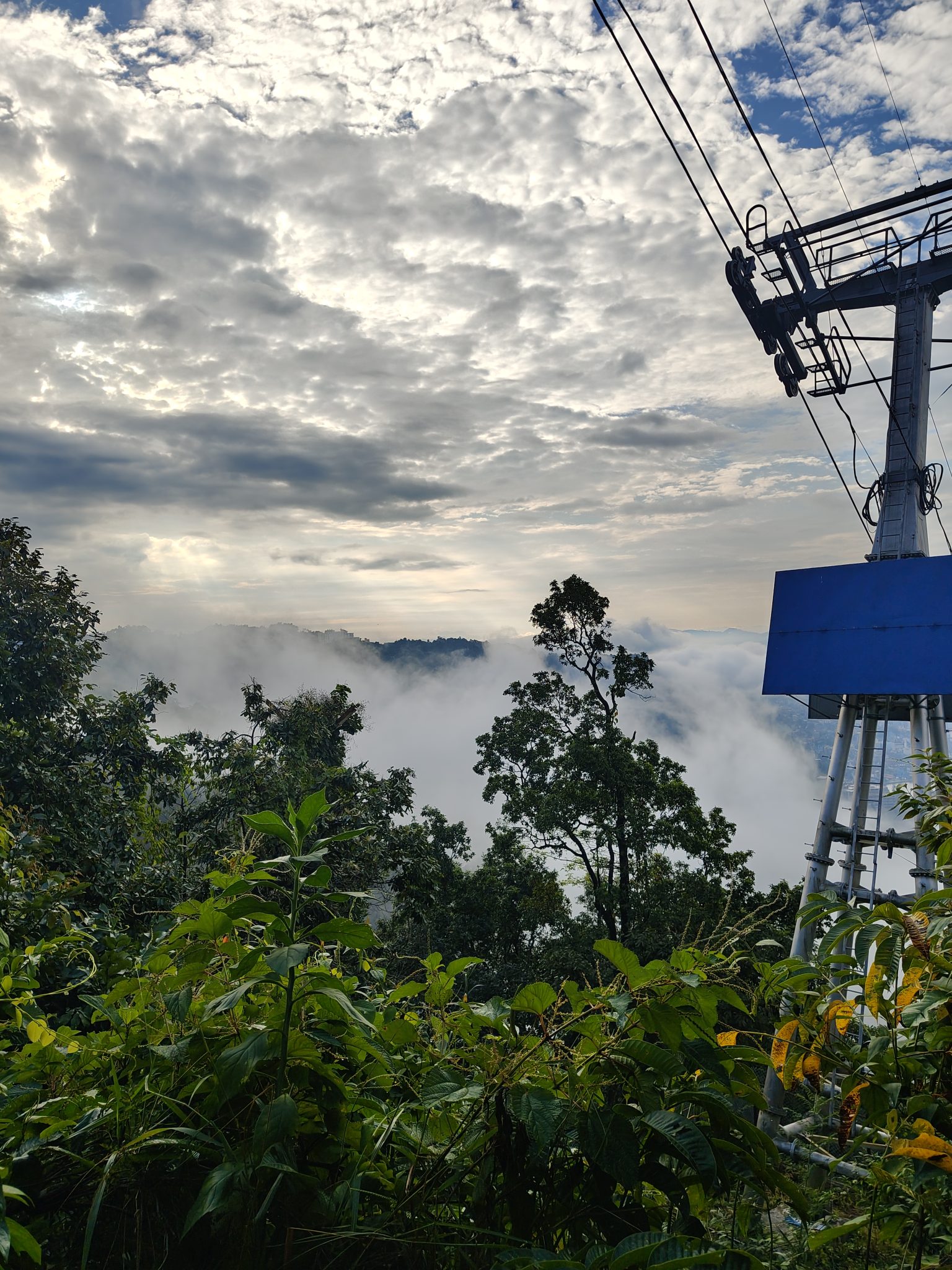Gün Batımında Sisli Dağların Üzerinde Süzülen Teleferik ve Bulut Denizi