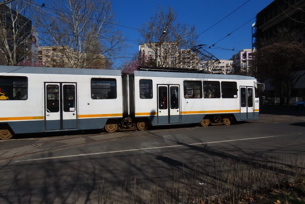 Güneşli Günde Şehir İçinden Geçen Beyaz Sarı Çizgili Tramvay Manzarası