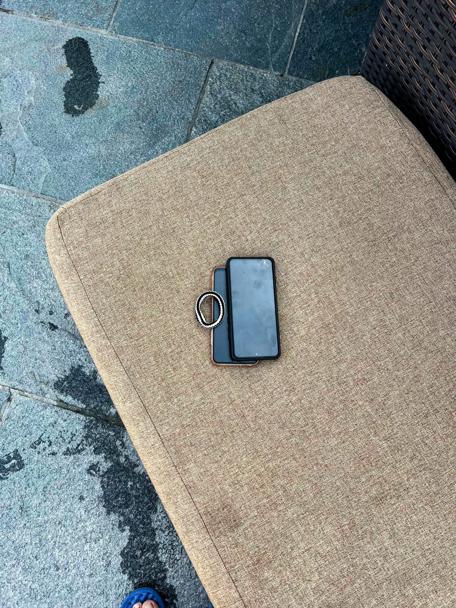 Havuz kenarında keten minder üzerinde unutulmuş telefon ve yüzük fotoğrafı