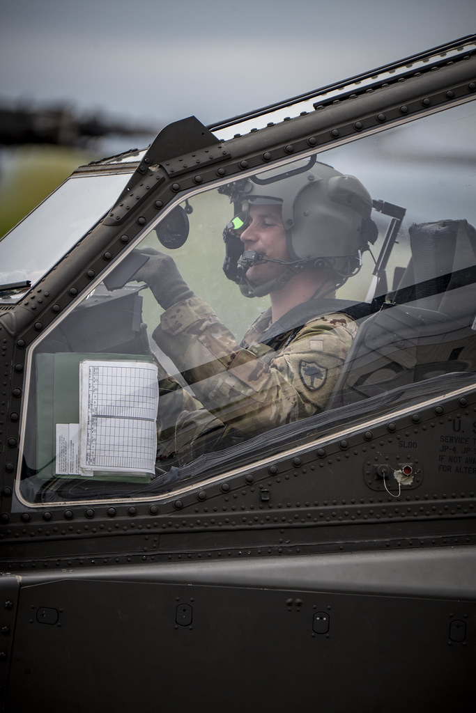 Helikopter kokpitinde görev yapan kasklı asker pilotun yakın çekim görüntüsü