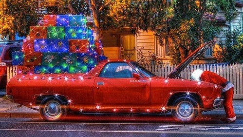 ışıklı hediyelerle dolu klasik kırmızı kamyonet ve tamir yapan noel baba