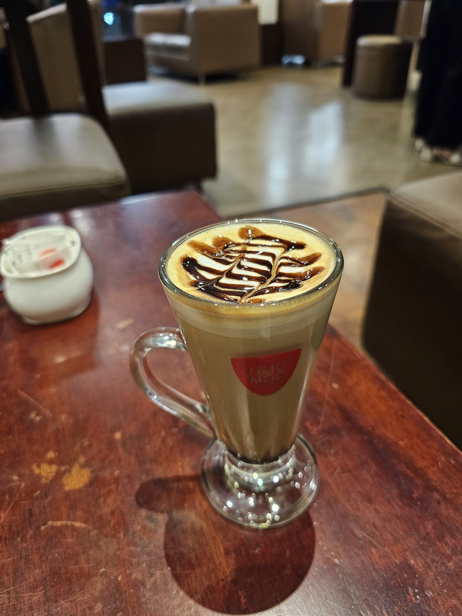 Kafe Köşesinde Çikolata Süslemeli Latte ve Sıcak İçecek Sunumu