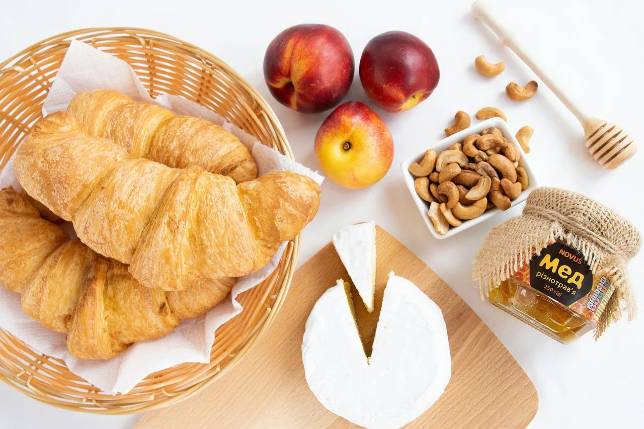 Kahvaltı masası üstten çekim: kruvasan, bal ve peynir