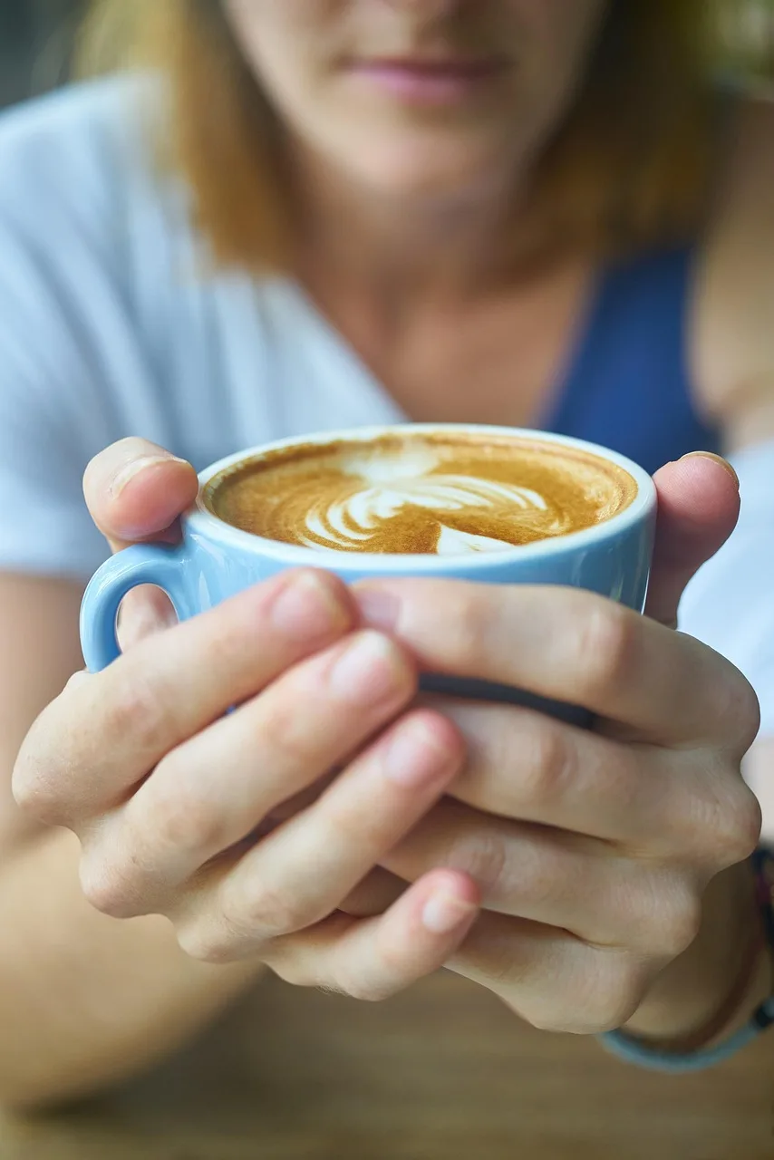 Kahve fincanı tutan kadın eli - kafe ortamı