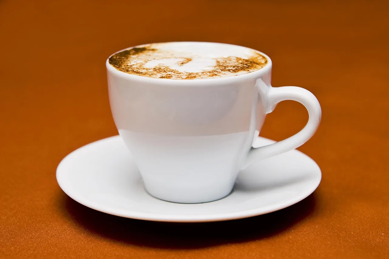Kahve kupası üstünde köpüklü cappuccino - sabah içeceği