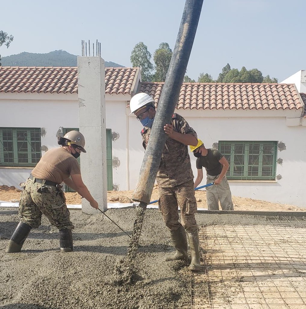 kamuflajlı askerler ve işçiler şantiyede beton döküm çalışması yapıyor kamuflajlı askerler ve işçiler şantiyede beton döküm çalışması yapıyor