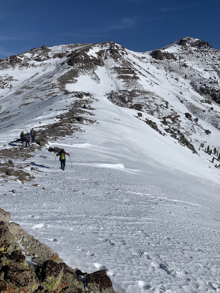 Karlı Dağ Zirvesinde Trekking Yapan Dağcılar ve Mavi Gökyüzü Manzarası