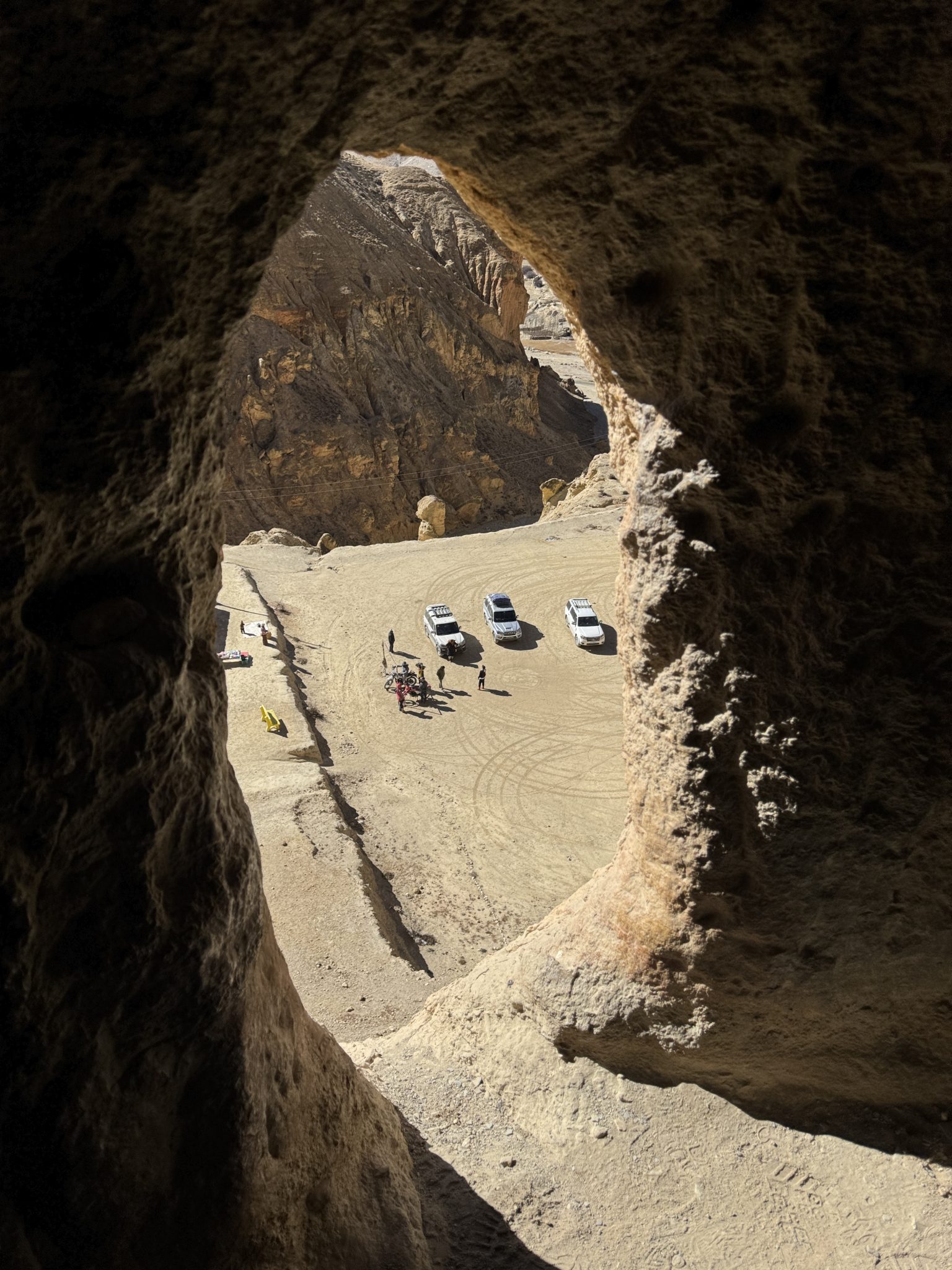 Kayalık Oluğun İçinden Araçların ve Dağların Göründüğü Eşsiz Arazi Manzarası Kayalık Oluğun İçinden Araçların ve Dağların Göründüğü Eşsiz Arazi Manzarası