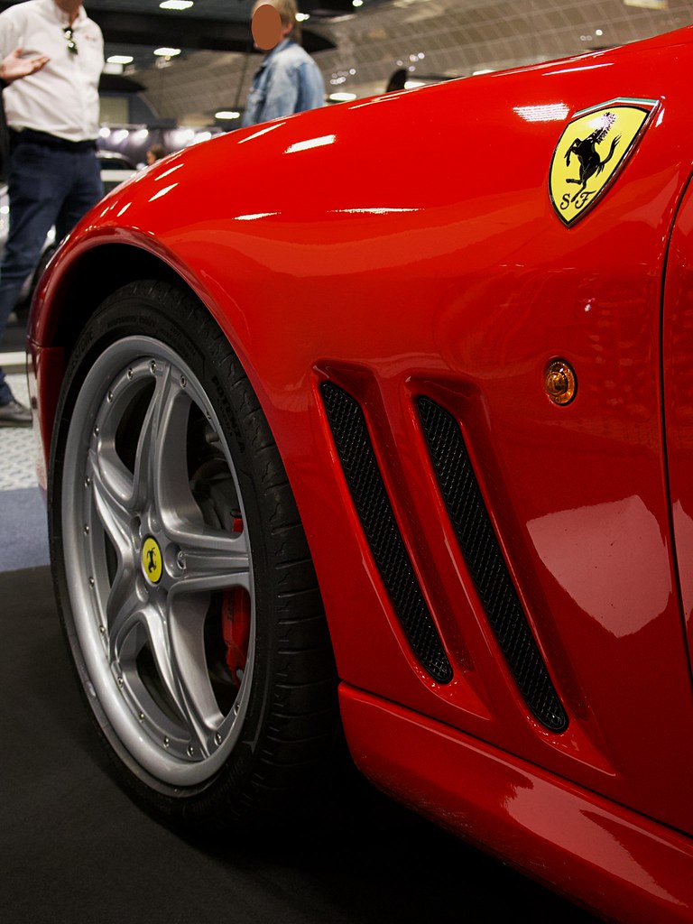 Kırmızı Ferrari yan detay: ikonik at logo, gümüş jant ve çift hava menfezi