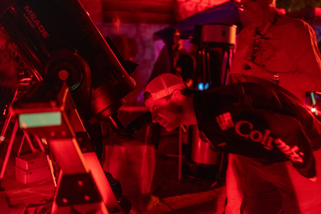 Kırmızı Işık Altında Teleskoptan Gökyüzünü Gözlemleyen Astronomi Tutkunları